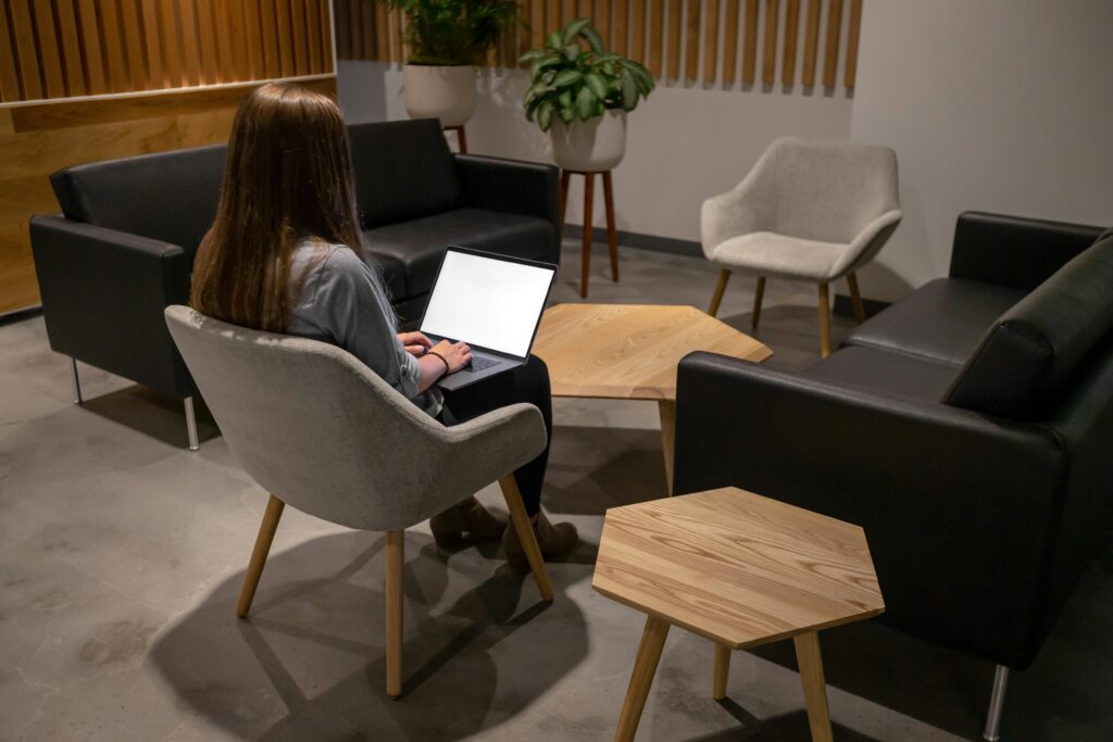 A woman sitting on an ergonomic chair using a laptop, showcasing the best office chairs for comfort and productivity.