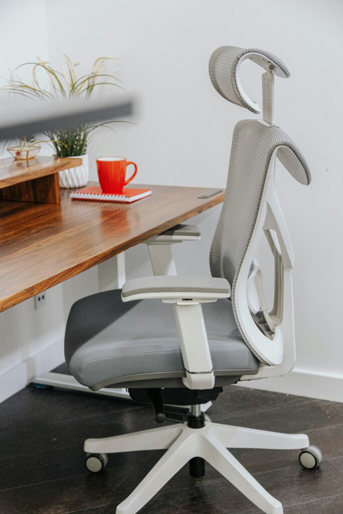Ergonomic chair for home office placed beside a wooden desk in a modern workspace